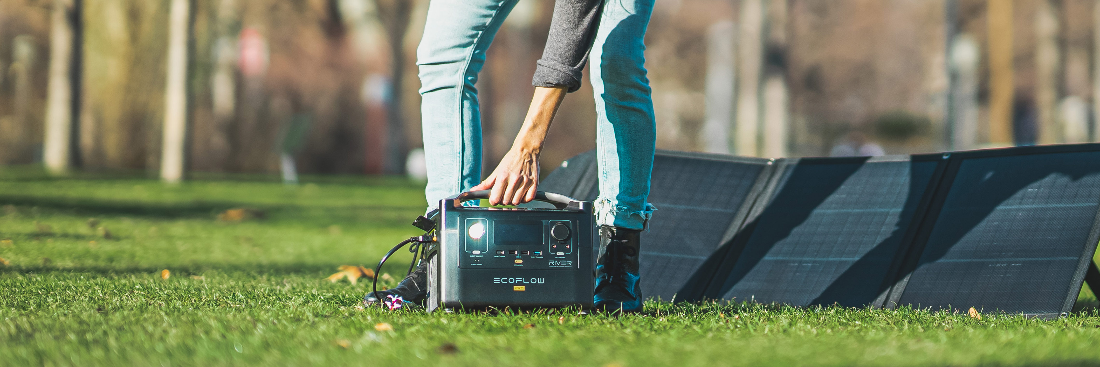 Aufbau eines faltbaren, mobilen Solarmoduls auf einer Wiese und Anschließen an eine Ladestation (Powerstation)